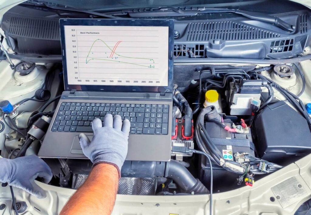 Professional car mechanic working in auto repair computer service
